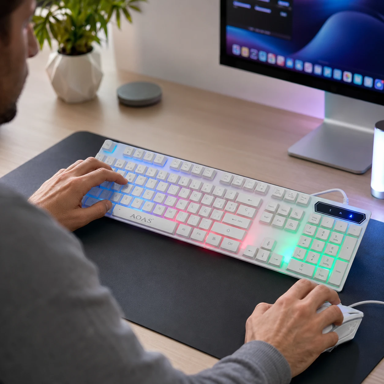 Persona adulta usando el teclado y mouse gamer AOAS M-400 en un escritorio.