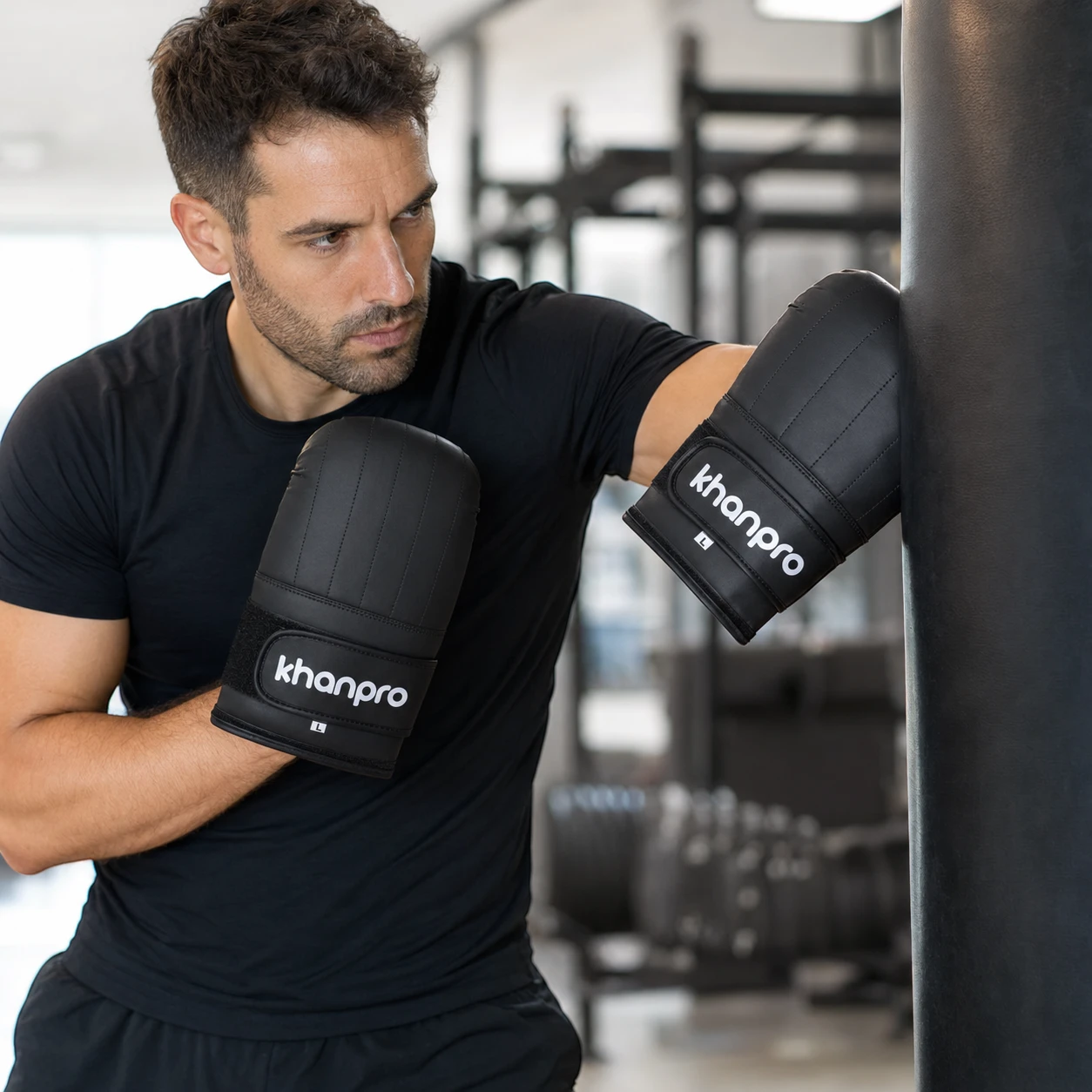 Deportista adulto entrenando con guantines Khanpro PU 908 negros talla L en gimnasio