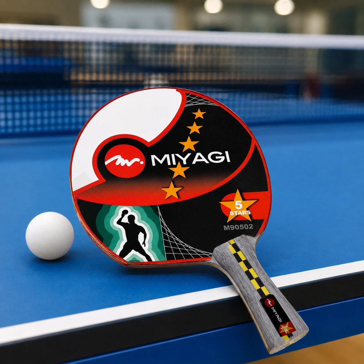 Raqueta profesional Miyagi 5 estrellas sobre mesa azul de tenis de mesa