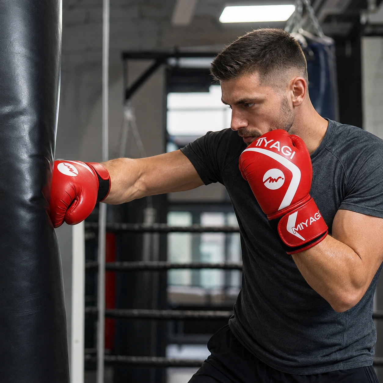 Deportista entrenando con guantes de boxeo Miyagi 14 oz rojos y blancos en gimnasio